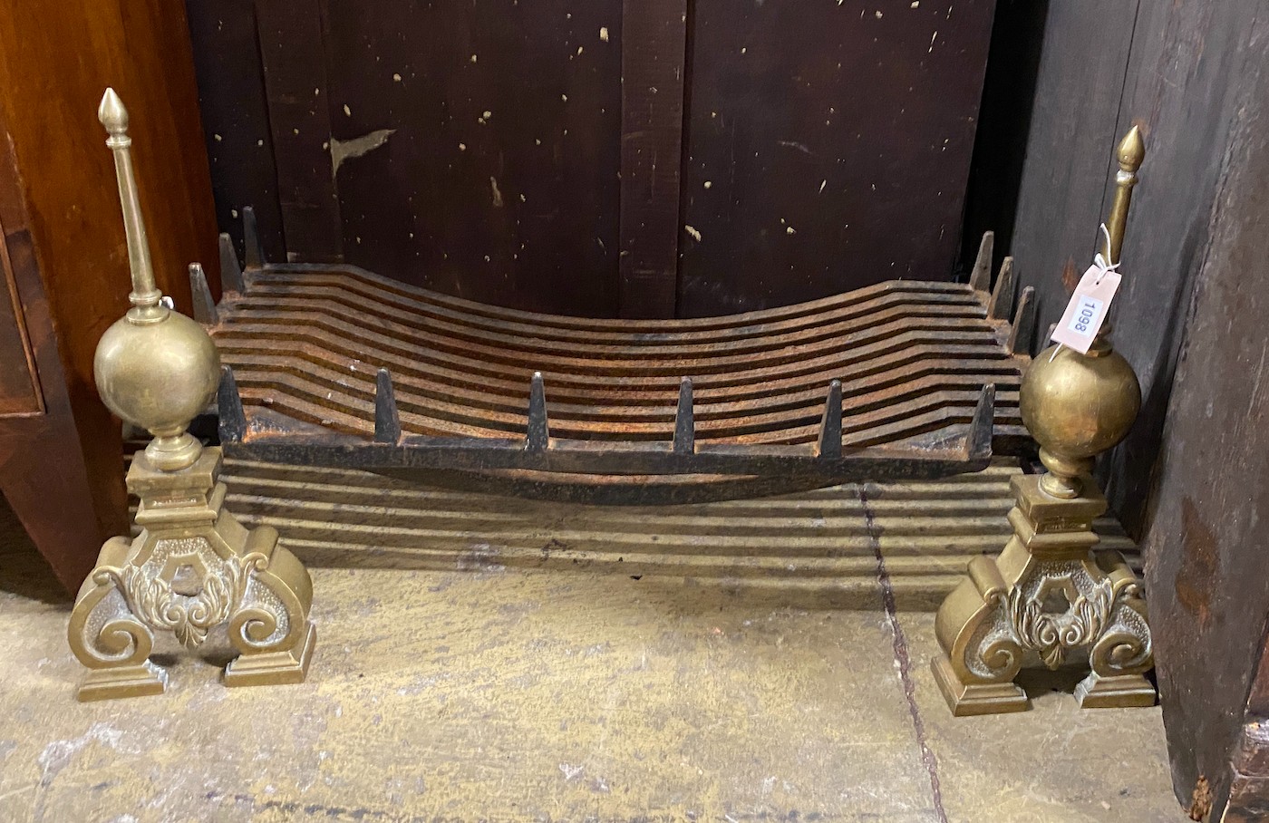 A cast iron rectangular fire grate, width 90cm, depth 42cm together with a pair of Dutch style brass dogs